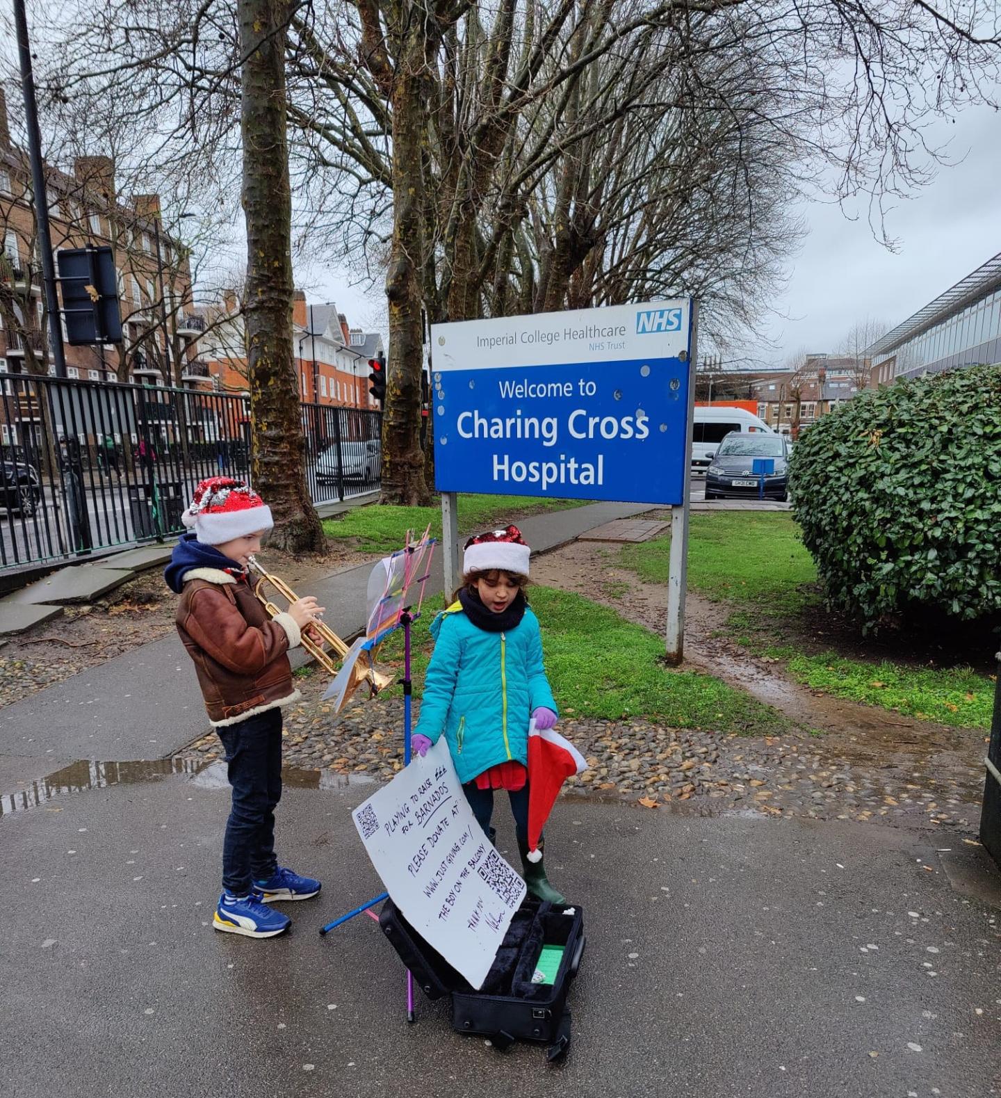 Boy playing trumpet outside hospital (fundraising)