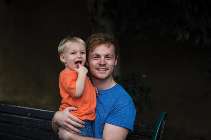 Adult male holding smiling boy