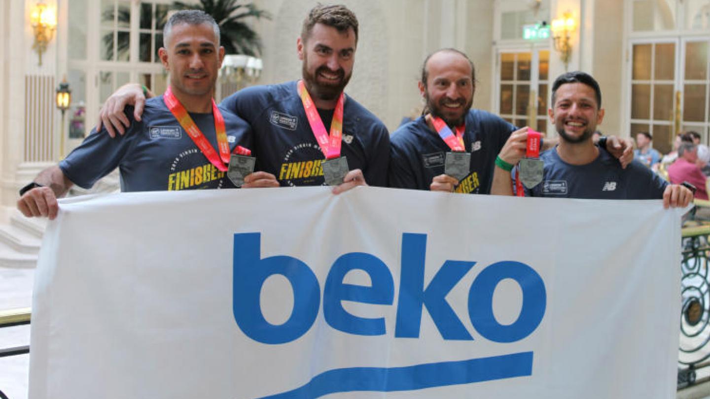 Beko employees holding up banner and their London Marathon medals