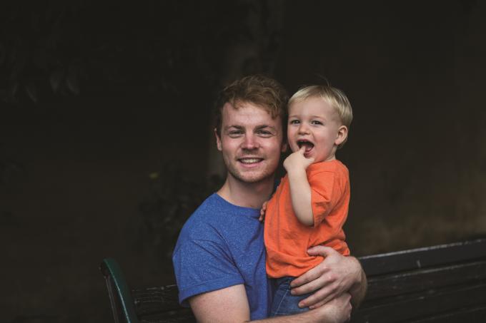 Man holding smiling toddler