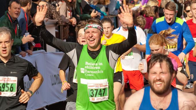 A runner wearing a Barnardo's vest in a crowd at the Cardiff Half Marathon 