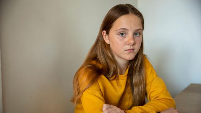 Young girl in yellow jumper looking sad