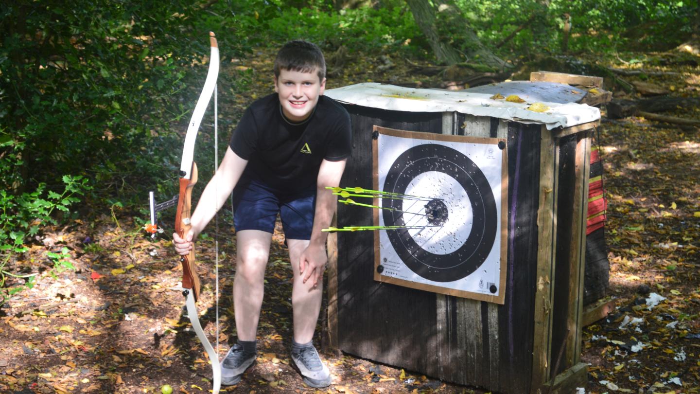 Boy standing beside archery target