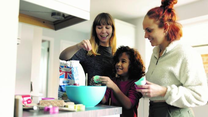 Two foster mums bake with a foster child