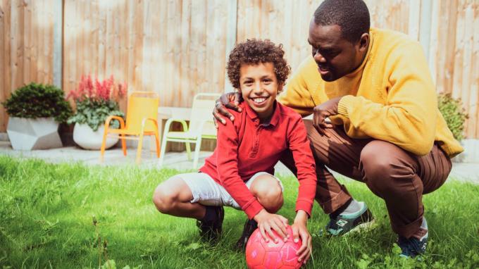 Young boy and foster carer playing with a football