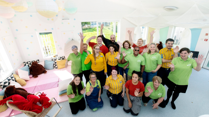 A group of Barnardo's and IKEA staff members waving 